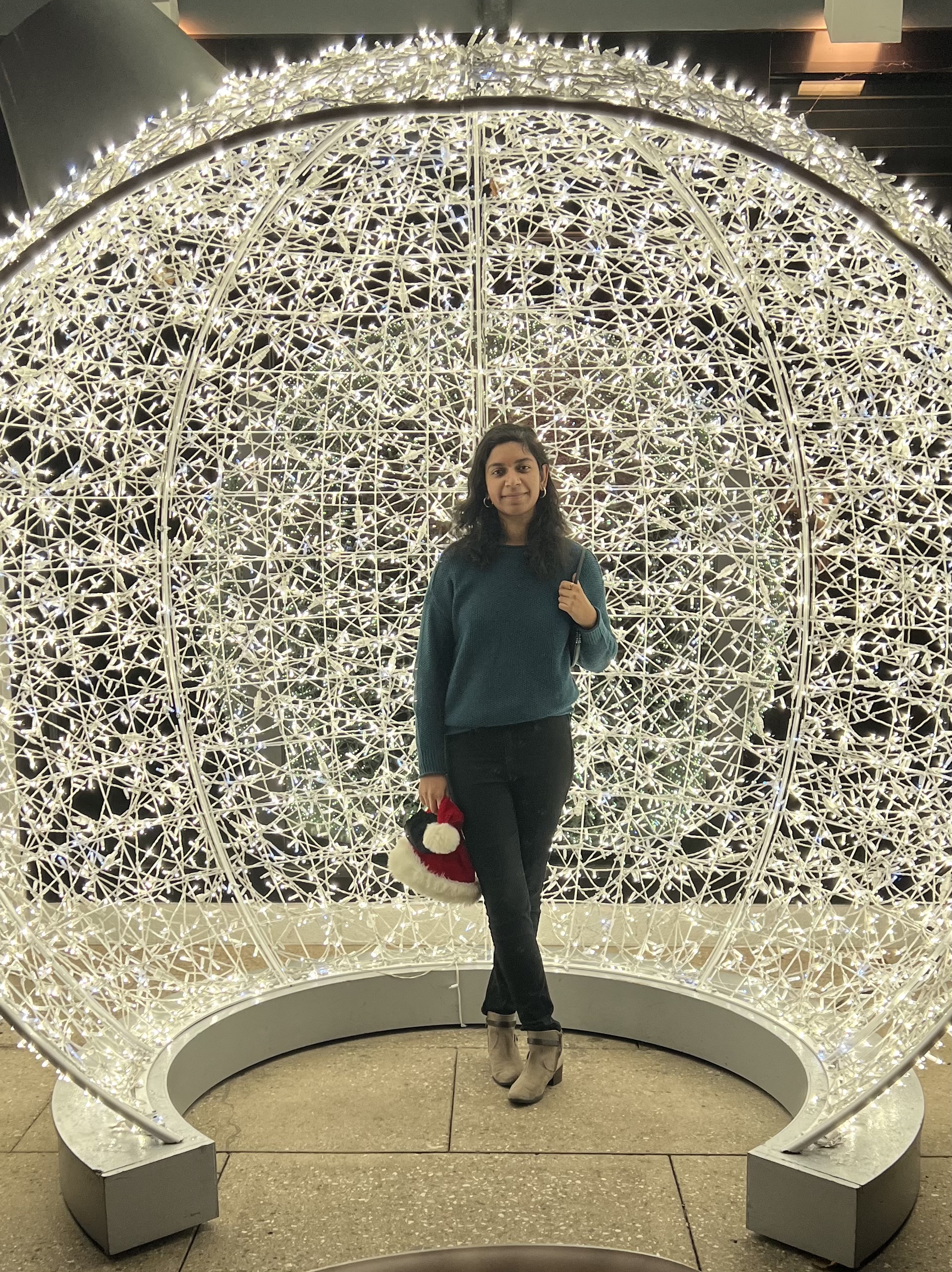 Harshali Wadge in front of a large illuminated holiday light sphere